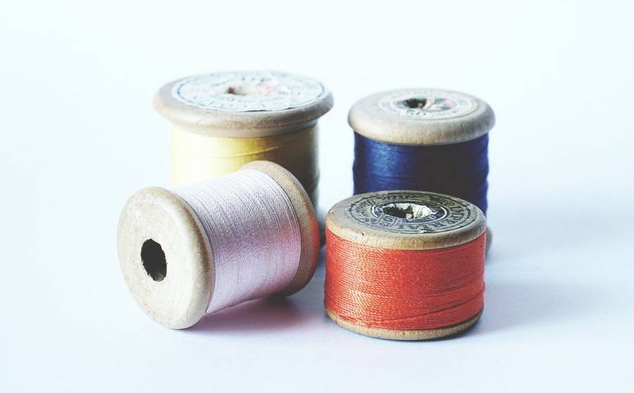Carretes de hilo de colores sobre madera