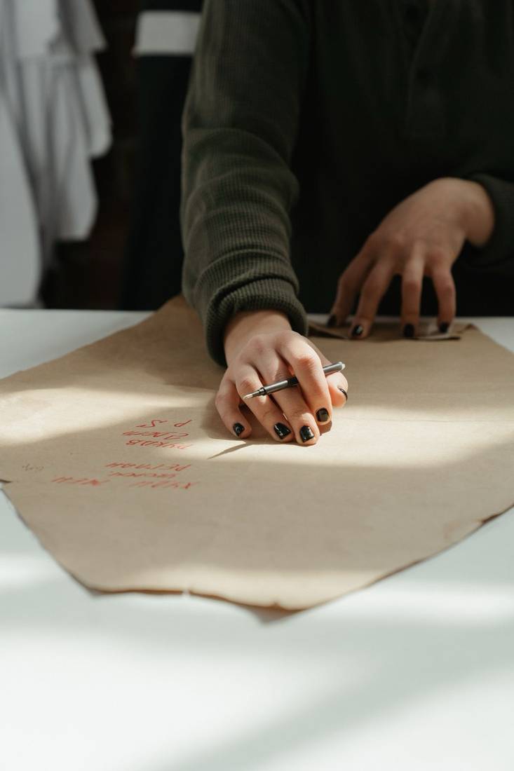 Mano trazando un patrón de costura sobre papel