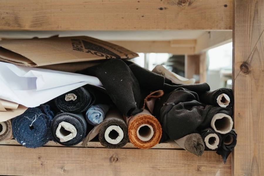 Rollos de tela ordenados sobre la mesa del taller